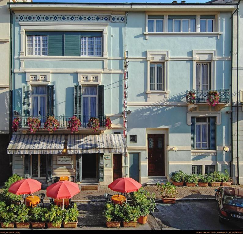 a building with red umbrellas in front of it at Hotel Massimo in Viareggio