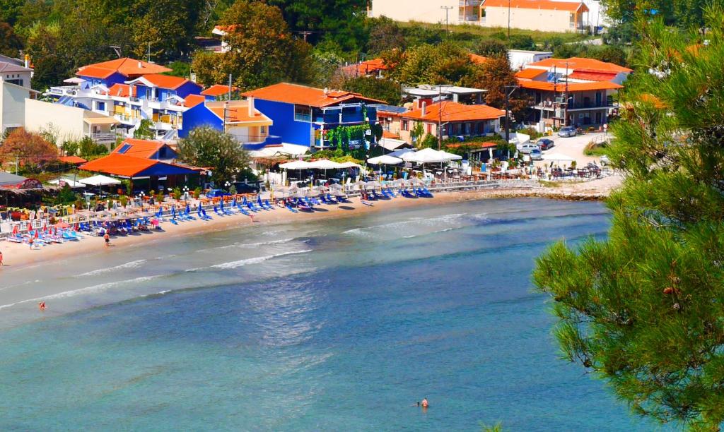 a beach with chairs and umbrellas and people on it at Blue Sea Beach Resort in Skala Potamias
