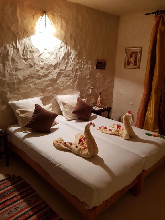 a bed with two animal slippers on it at Menzel Churasco Djerba in Aghīr