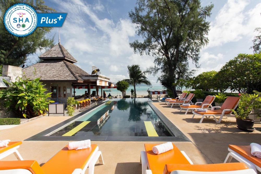 a pool at the resort with lounge chairs and tables at Samui Honey Cottages Beach Resort - SHA Extra Plus in Choeng Mon Beach
