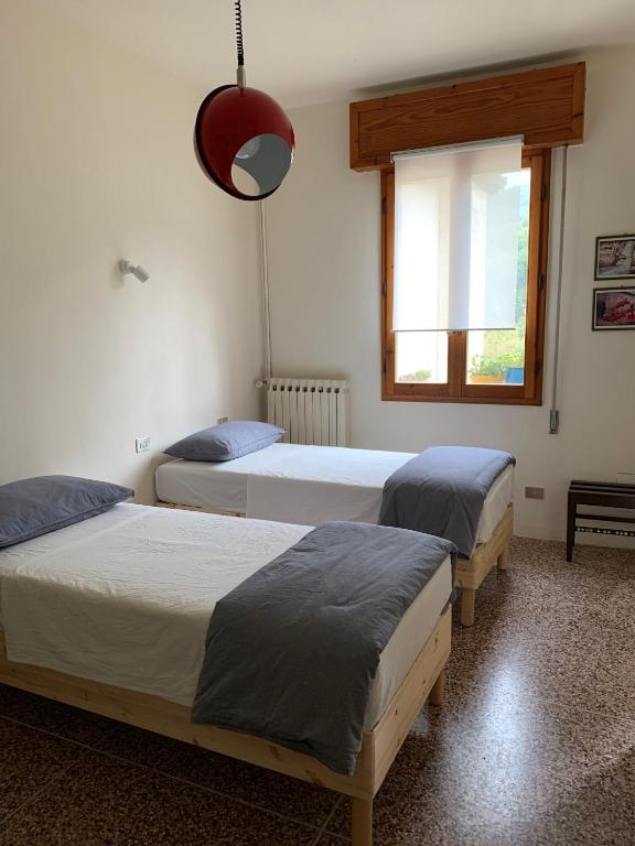Castel del Rio的住宿－camiBB，一间卧室设有两张床和窗户。