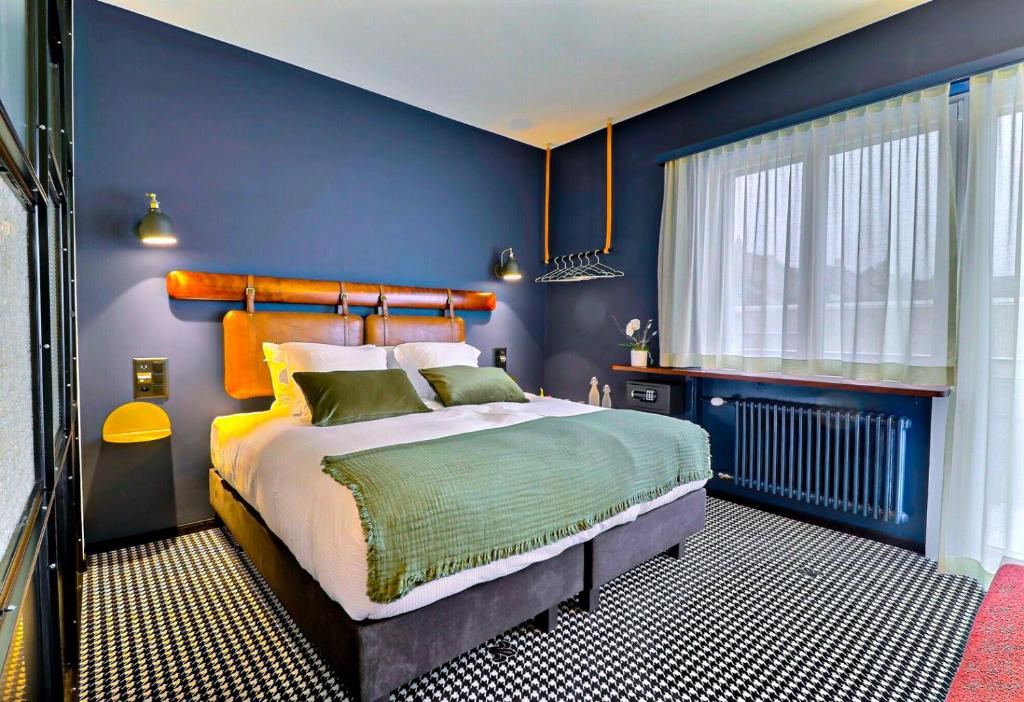 niebieska sypialnia z łóżkiem i oknem w obiekcie Le Tonnelier w mieście Bulle