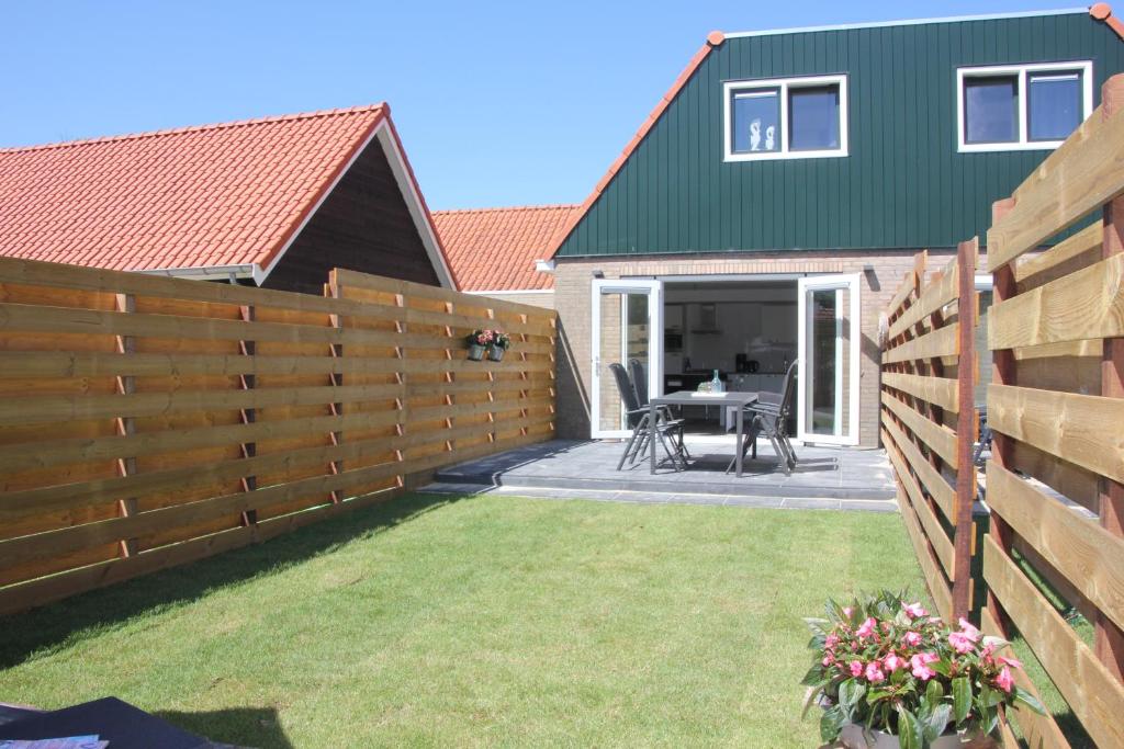 a fence in front of a house with a patio at Zeerust in Buren