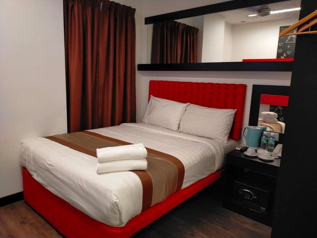 Lazdana Hotel Kuala Lumpur في كوالالمبور: غرفة نوم بسرير كبير مع اللوح الأمامي الأحمر