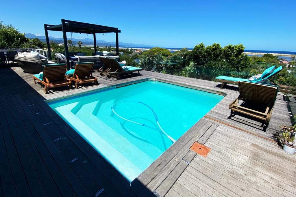 a swimming pool with chairs and a gazebo at Lasalle holiday home (Sun, Beach, Views, Fun for everyone!) in Plettenberg Bay