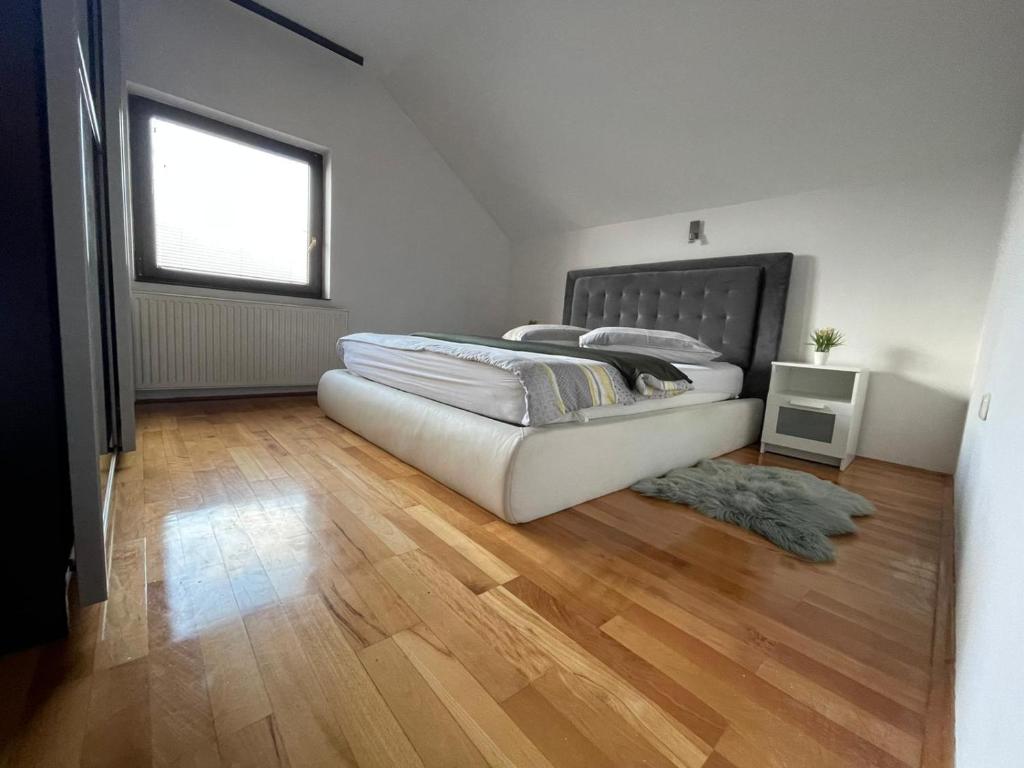 1 dormitorio con 1 cama y suelo de madera en Komfort Apartman Bilivano, en Zagreb