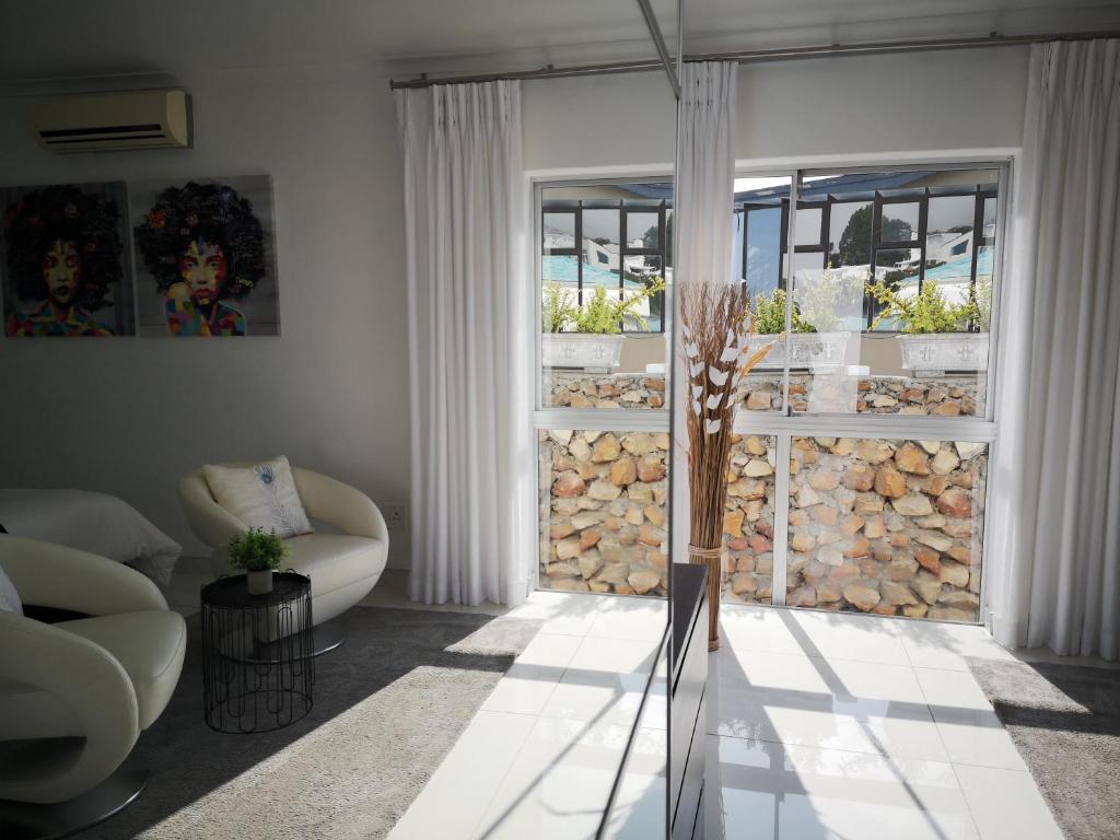 a living room with a couch and a window at Diamond House Guesthouse in Cape Town