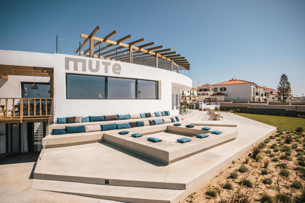 a building with couches on the side of it at MUTE Hostel Porto Covo in Porto Covo