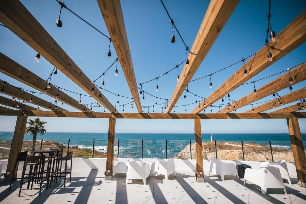 a room with chairs and a view of the ocean at MUTE Hostel Porto Covo in Porto Covo