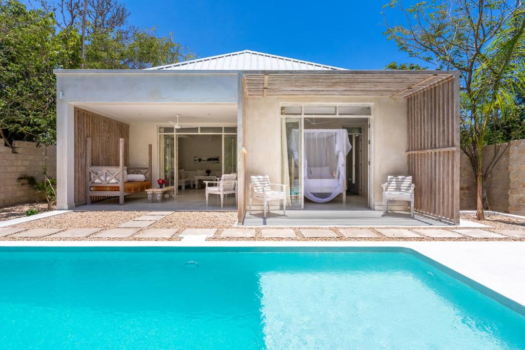 - une piscine en face d'une maison dans l'établissement Saffron Villas, à Diani Beach