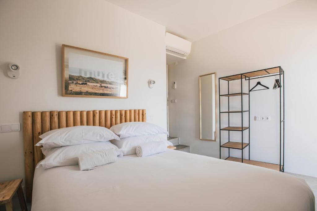 a bedroom with a large white bed with white pillows at MUTE Hostel Porto Covo in Porto Covo