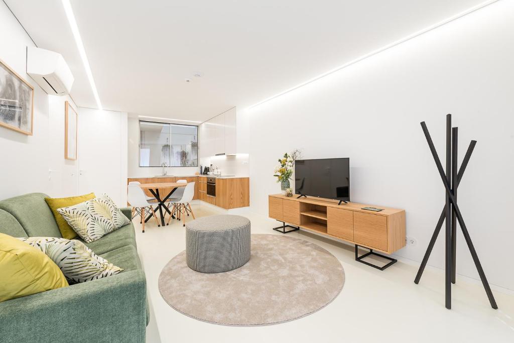 - un salon avec un canapé vert et une télévision dans l'établissement Lidador 116 Apartments, à Vila do Conde