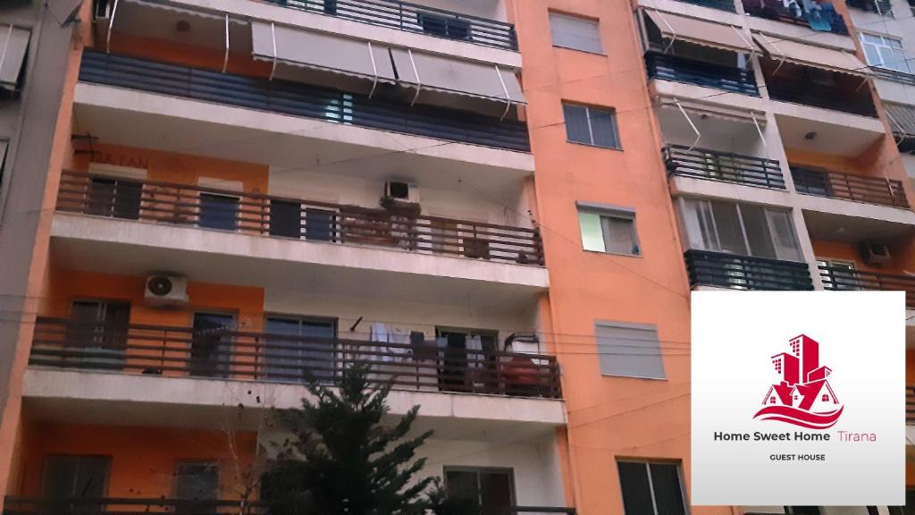 un edificio de apartamentos con un cartel en el costado en Home Sweet Home - Guest House, en Tirana