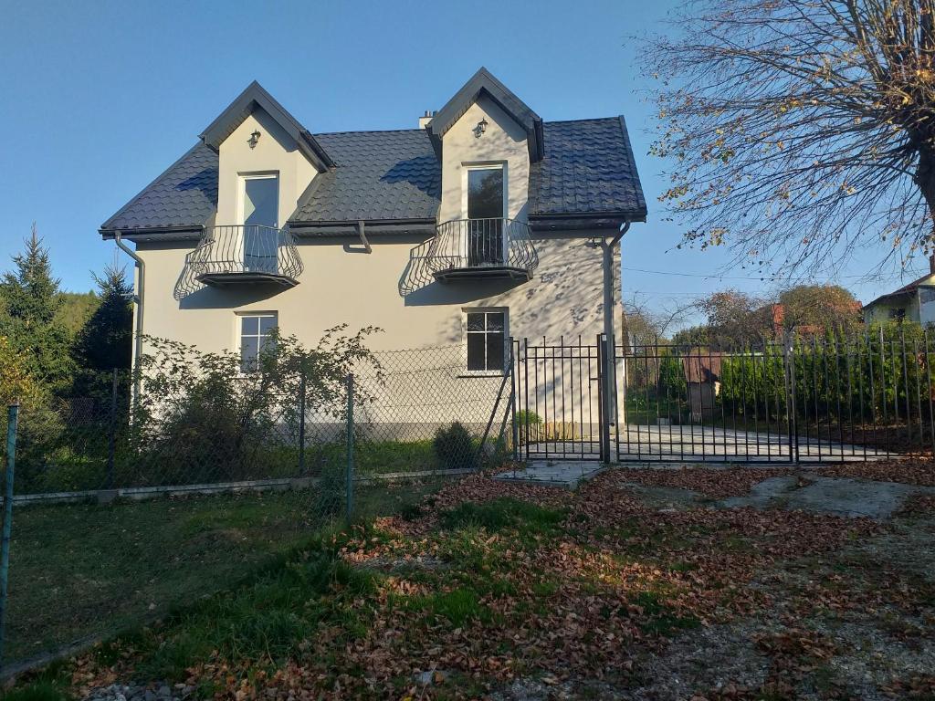 une maison avec une clôture devant elle dans l'établissement Krasiczyn nocleg, à Krasiczyn