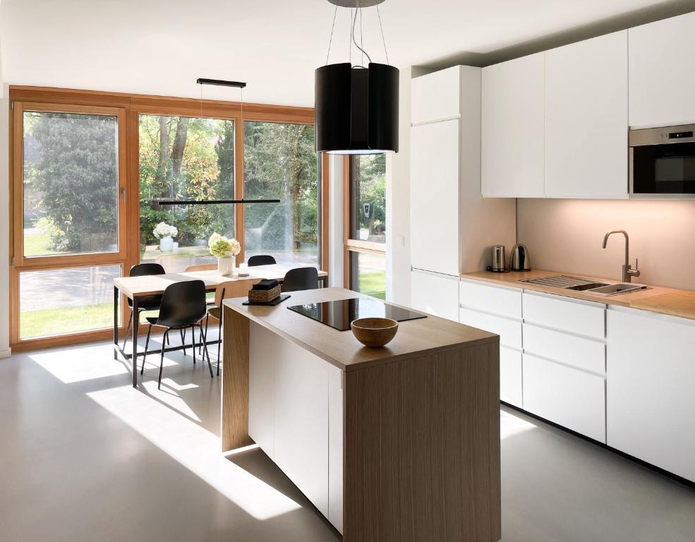 a kitchen with white cabinets and a table with chairs at Haus Meerling in Rerik