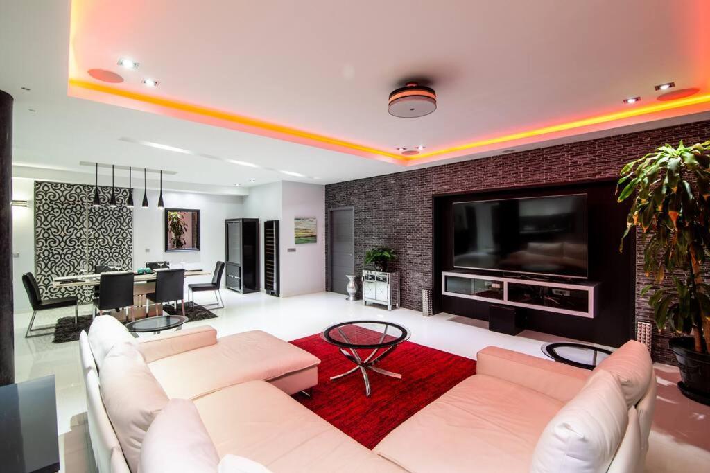 een woonkamer met een bank en een tv bij Skyline Luxury 5 Star Condo in Maho Reef