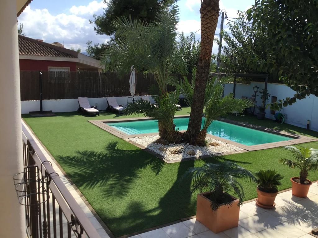 a backyard with a swimming pool and palm trees at Relax en la huerta de Murcia in Murcia