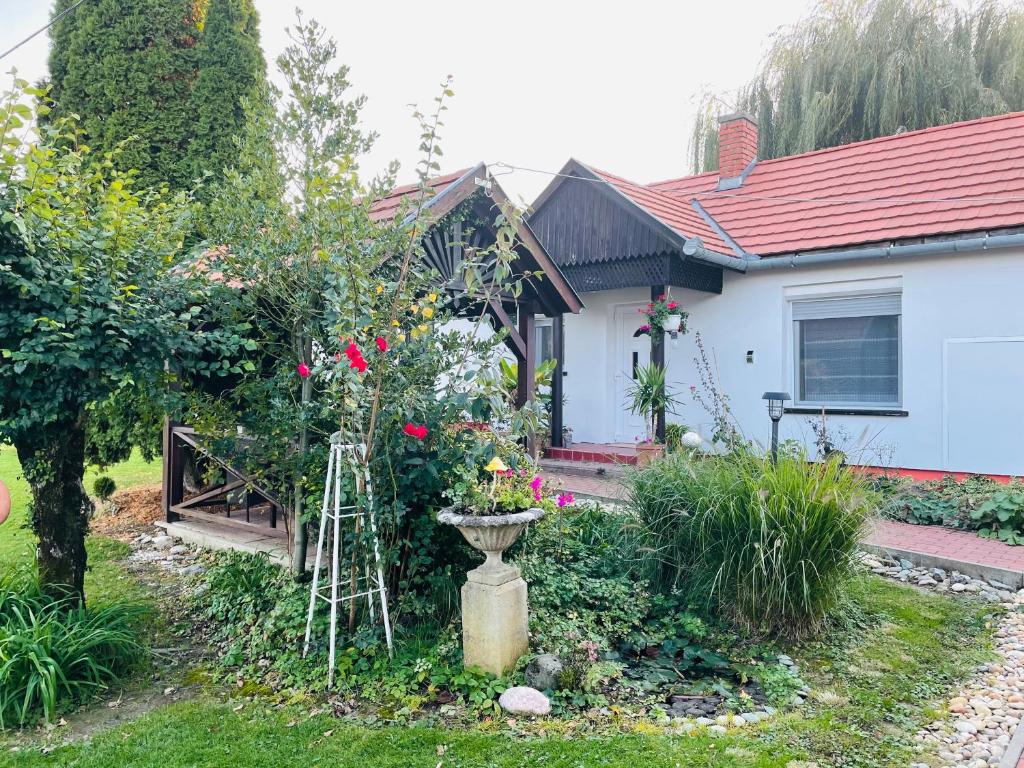 ein Haus mit einem Garten mit Blumen im Hof in der Unterkunft Noé Bárkája Vendégház in Nagyrákos