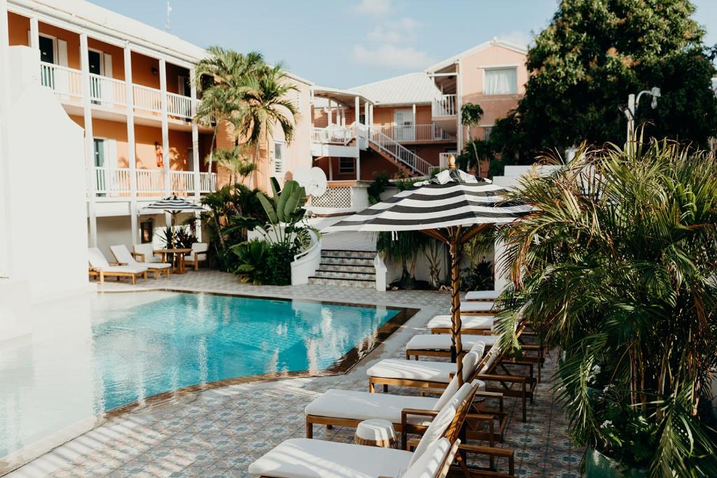 una piscina con sillas y sombrillas junto a un edificio en King Christian Hotel, en Christiansted