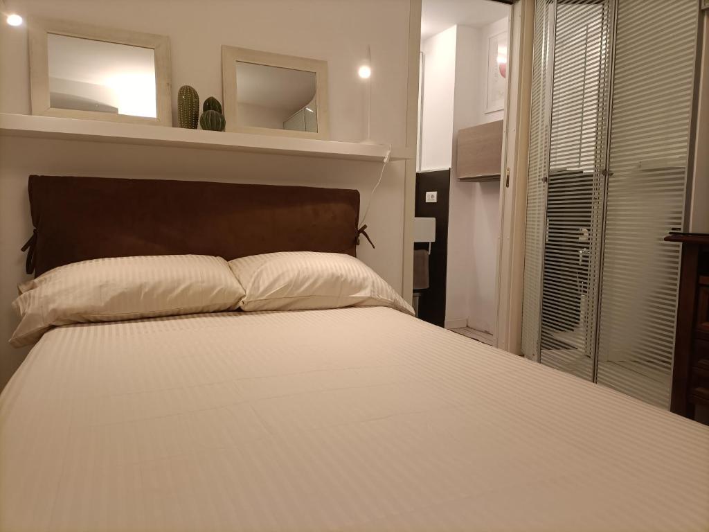 a bedroom with a large white bed and a window at BE MY GUEST charme e relax in citta' alta in Bergamo