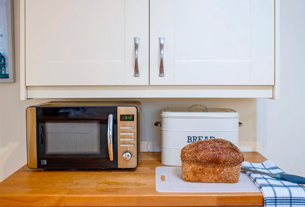 a microwave and a loaf of bread on a counter at The Old Stables in Tetbury