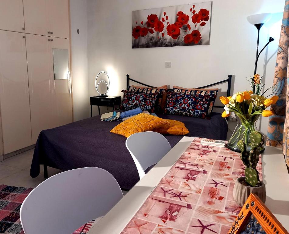 a bedroom with a bed and a table with chairs at Ariadne 1, Sea Side Boutique Apartment in Limassol