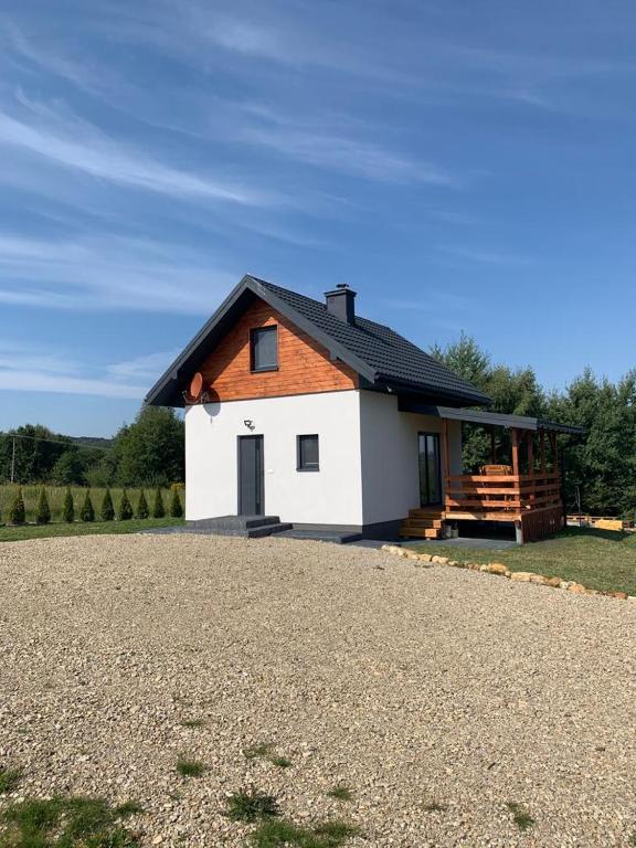 a small white house with a black roof at Ostoja Wilka in Grochowce