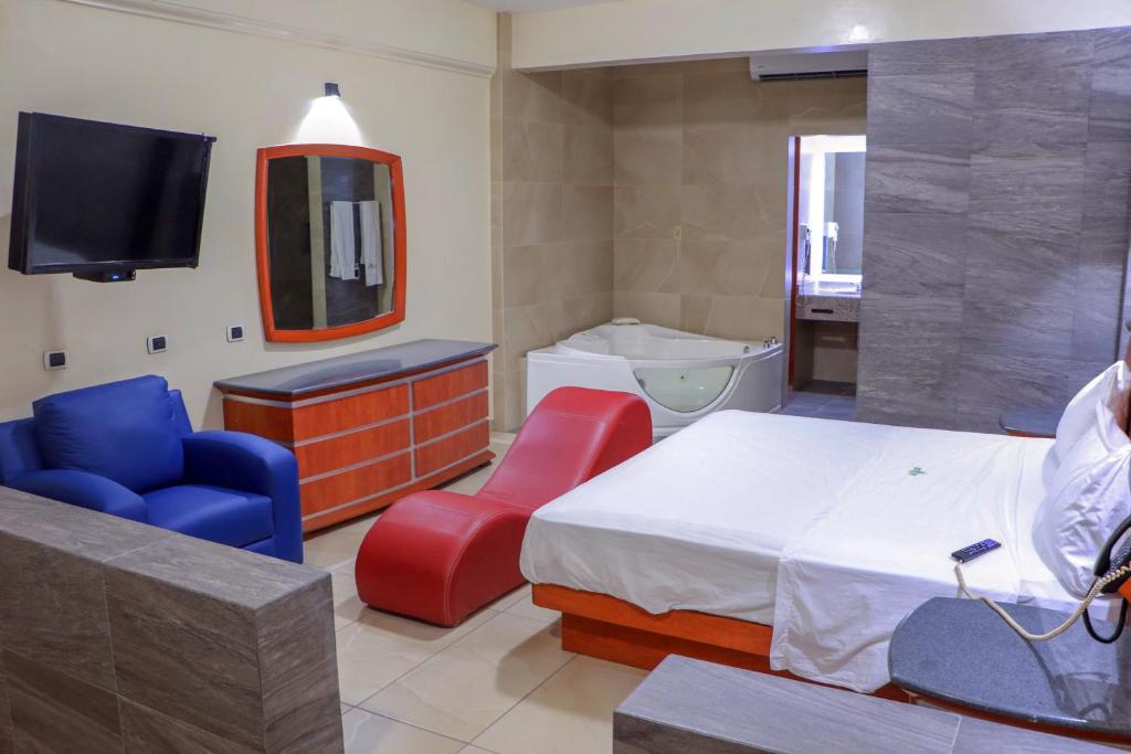 Autohotel Ilussion في كوردوبا: غرفة نوم بسرير وتلفزيون وحوض استحمام