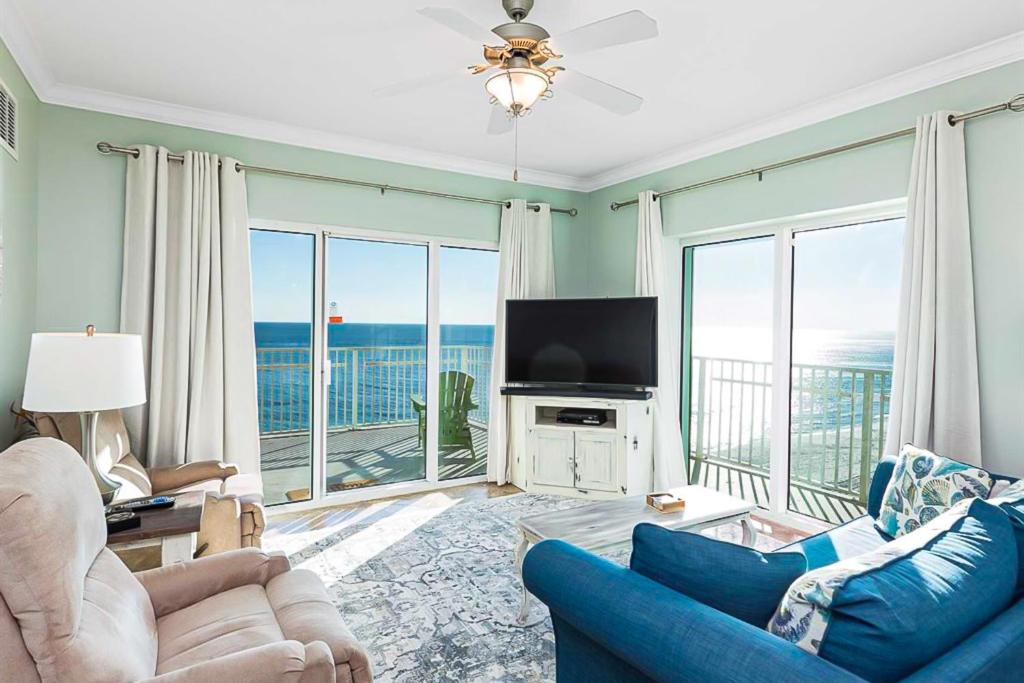 a living room with a blue couch and a television at Crystal Shores West II in Gulf Shores