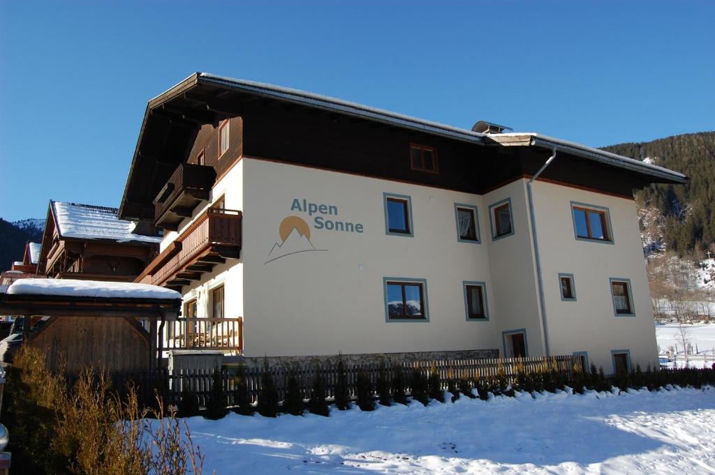 a building with a sign on it in the snow at Alpensonne in Krimml