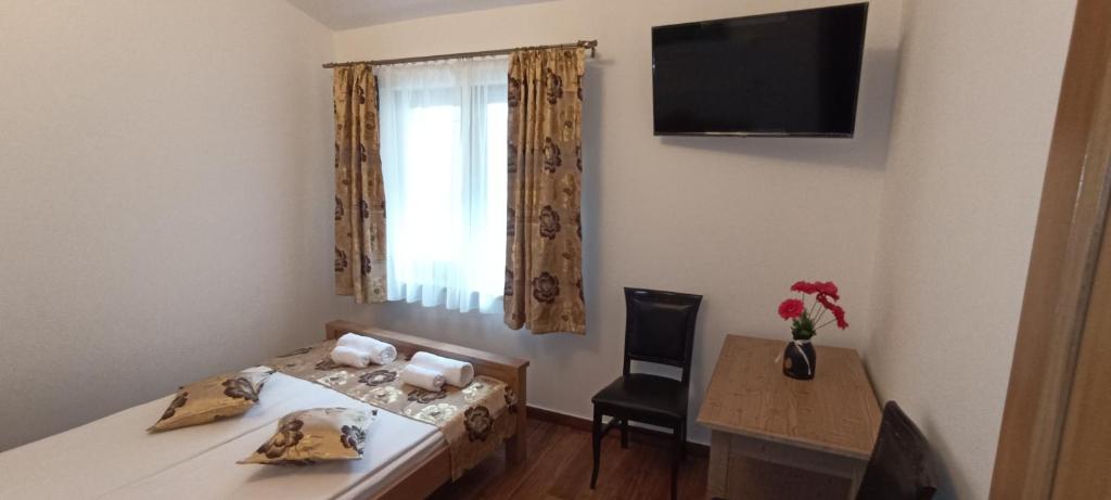 a room with a bed and a table and a window at Medieval Apartment in Sighişoara