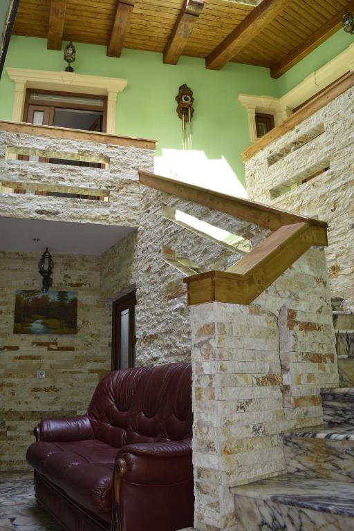- un canapé en cuir dans un salon avec un mur en pierre dans l'établissement Pensiunea Nobil Medieval, à Sighişoara