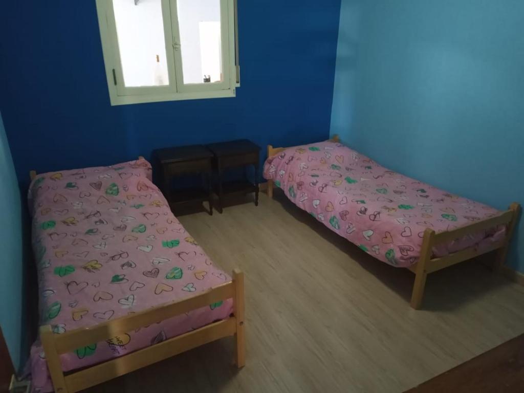1 dormitorio con 2 camas y ventana en Rufina Alojamiento en Playa Unión