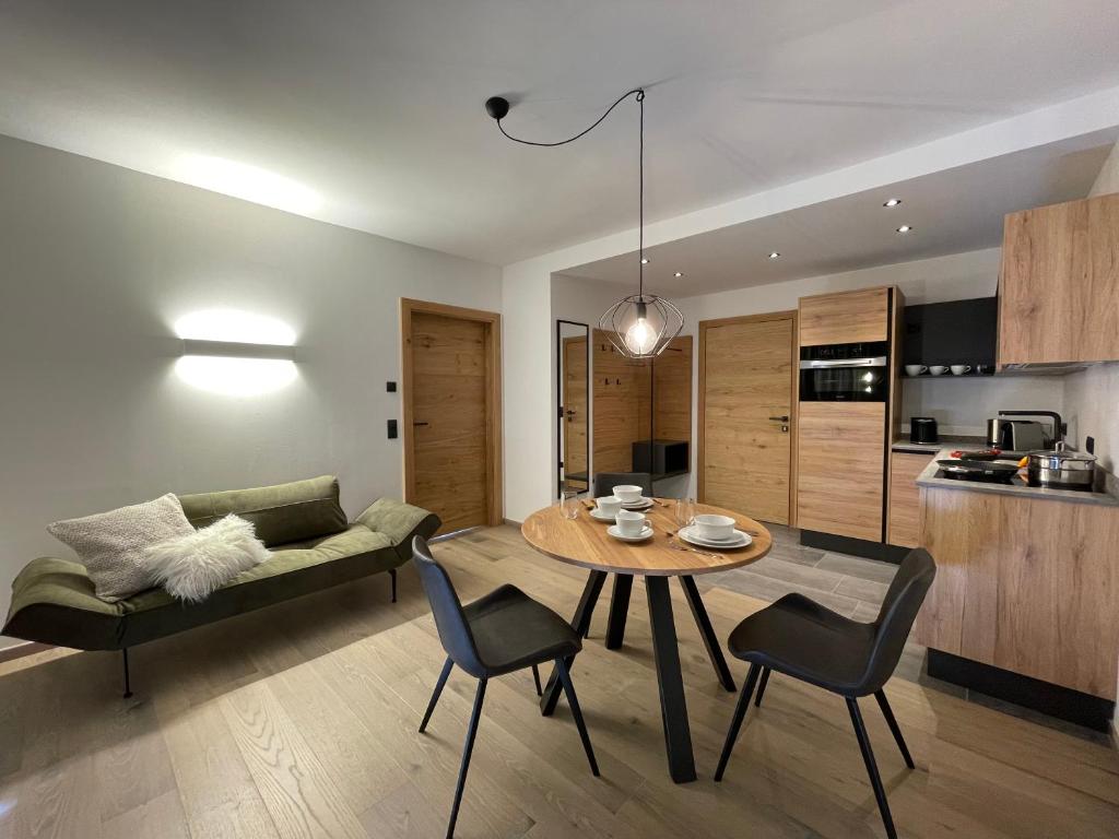 a living room with a table and chairs and a kitchen at HAUSZEIT APPARTEMENTS in Haus im Ennstal