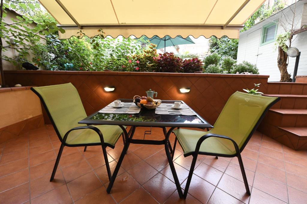 un tavolo e 2 sedie su un patio di Il giardino nascosto a Roma