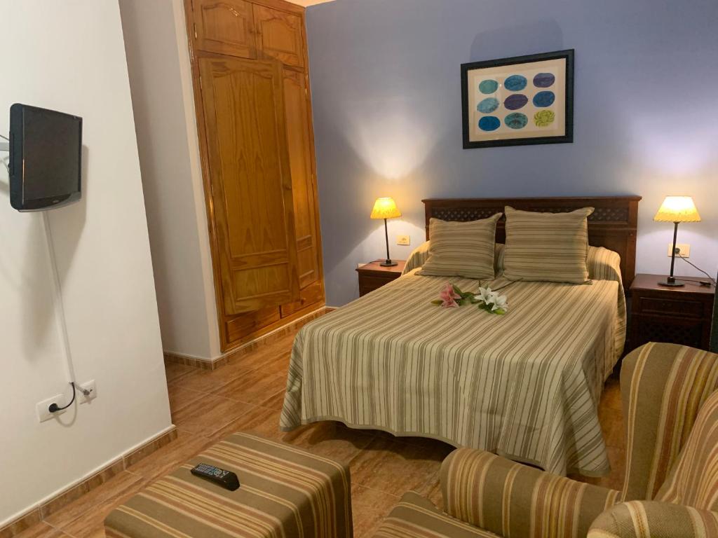 Un dormitorio con una cama con flores. en Apartamento en La Gomera, Playa de Santiago, Alajeró en Playa de Santiago