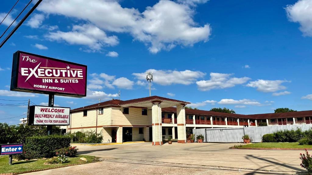 ein Gebäude mit einem Schild, das den Executive Gasthof und die Suiten liest in der Unterkunft Executive Inn and Suites Houston in Houston