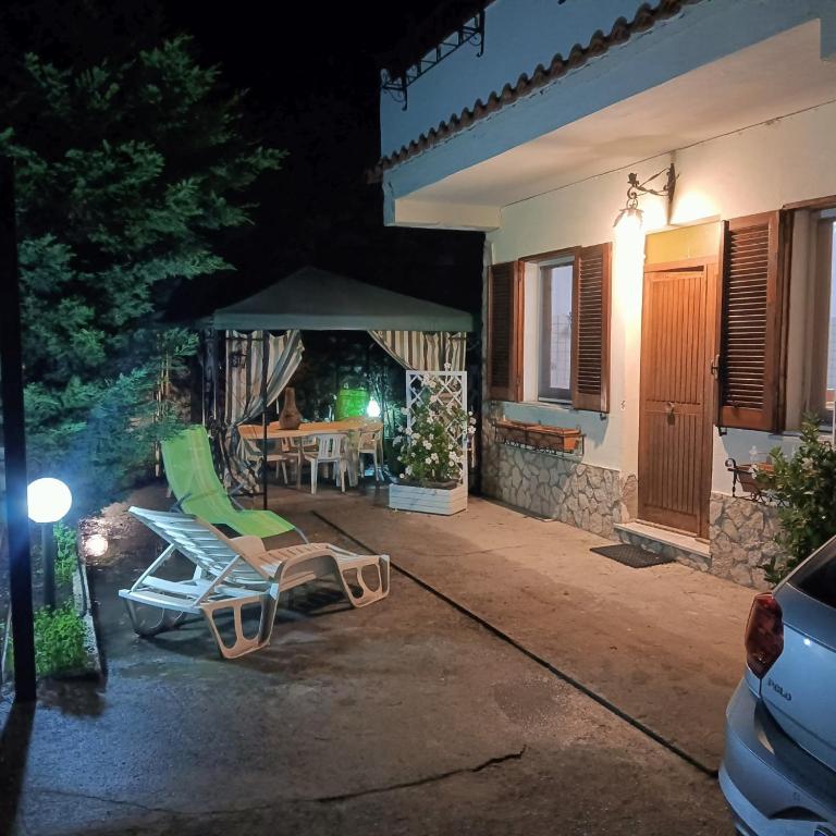 a patio at night with a green chair and a table at Calabrian Home in Casa Roccani