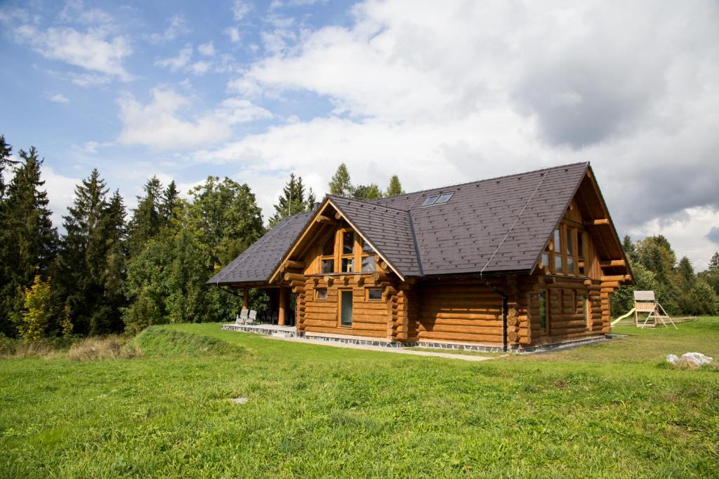 uma cabana de madeira com um telhado preto em Luxusní srub až 24 lůžek - Sruby-lipno em Frymburk