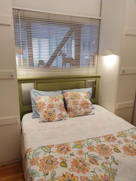 ein Bett mit zwei Kissen und ein Fenster in einem Zimmer in der Unterkunft April Bridge House in Lissabon