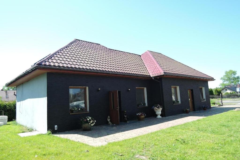 a black and white house with a grass yard at Semi-detached house, Swinoujscie in Świnoujście
