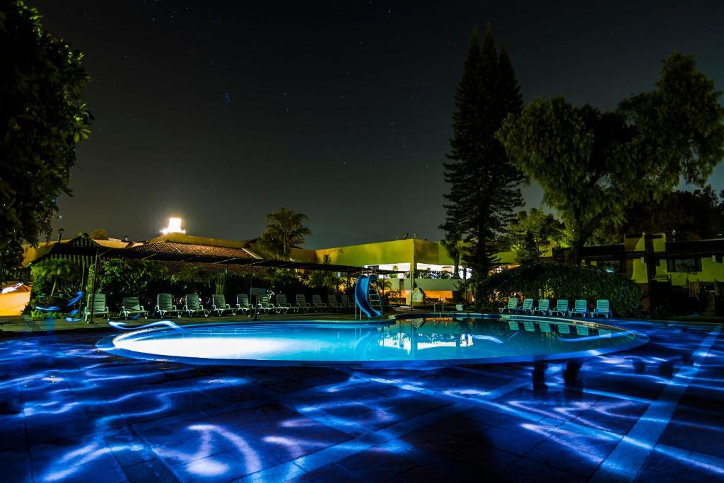 una piscina por la noche con luces azules en Hotel Soleil La Antigua, en Antigua Guatemala