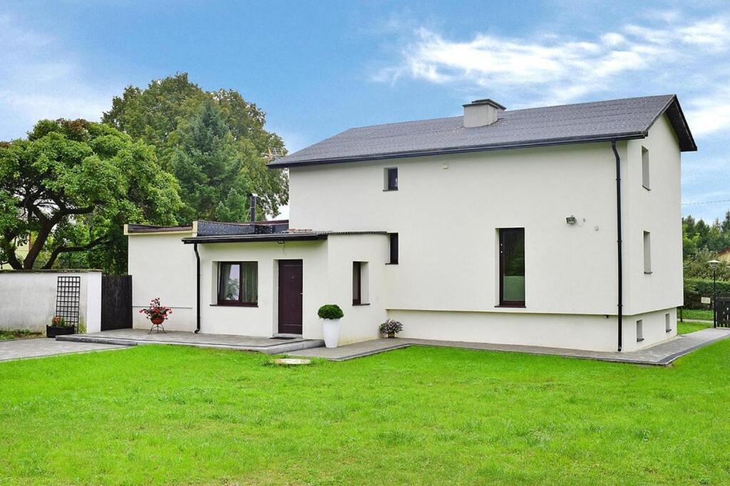 uma casa branca com um relvado verde em frente em Holiday flat, Kamien em Kamień