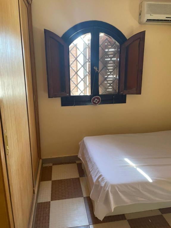 a small bedroom with a bed and a window at Seif's house in Dahab