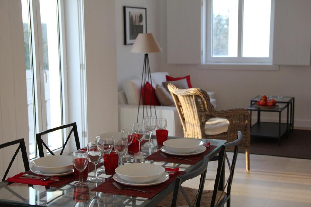 uma sala de jantar com uma mesa com pratos e copos de vinho em Quintas de Obidos Apartments no Vau