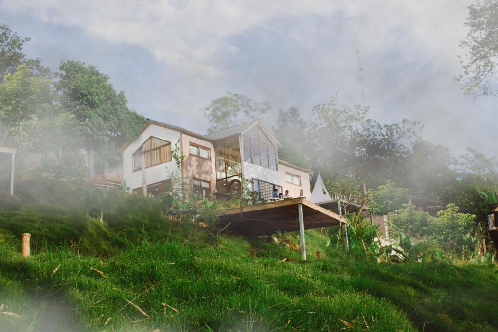 a house sitting on top of a lush green field at MiCasa - Nhà gác mái trên đỉnh đồi in Cao Bằng