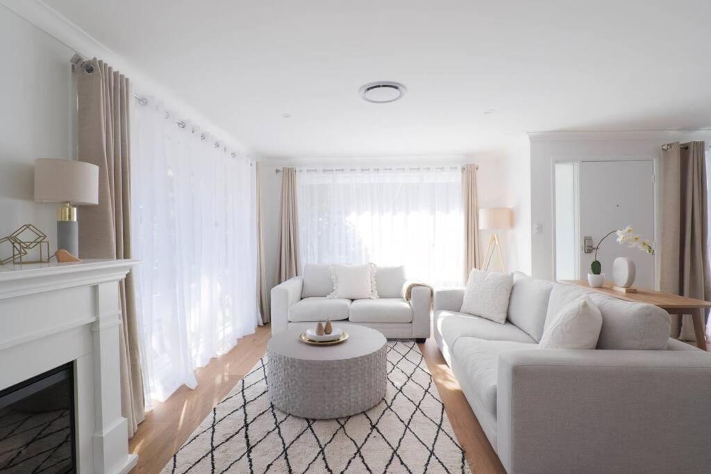 ルーラにあるAbbey House - 3BR/sleeps 8 - South Leuraのリビングルーム(白いソファ2台、暖炉付)