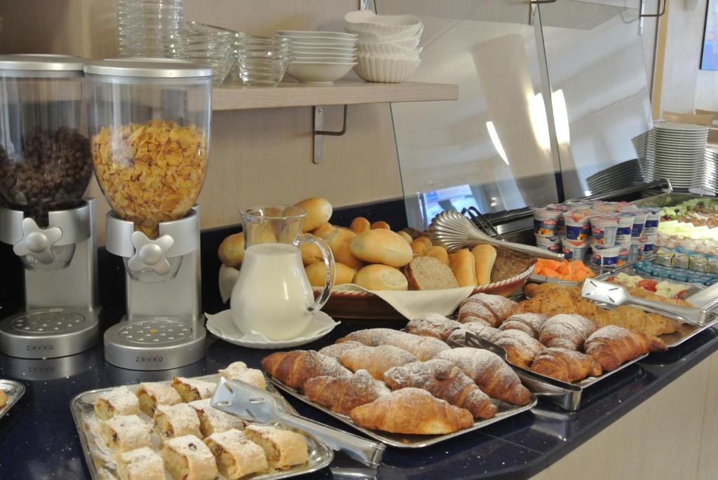 a buffet of pastries and other food on a counter at Hotel Bologna in Lignano Sabbiadoro