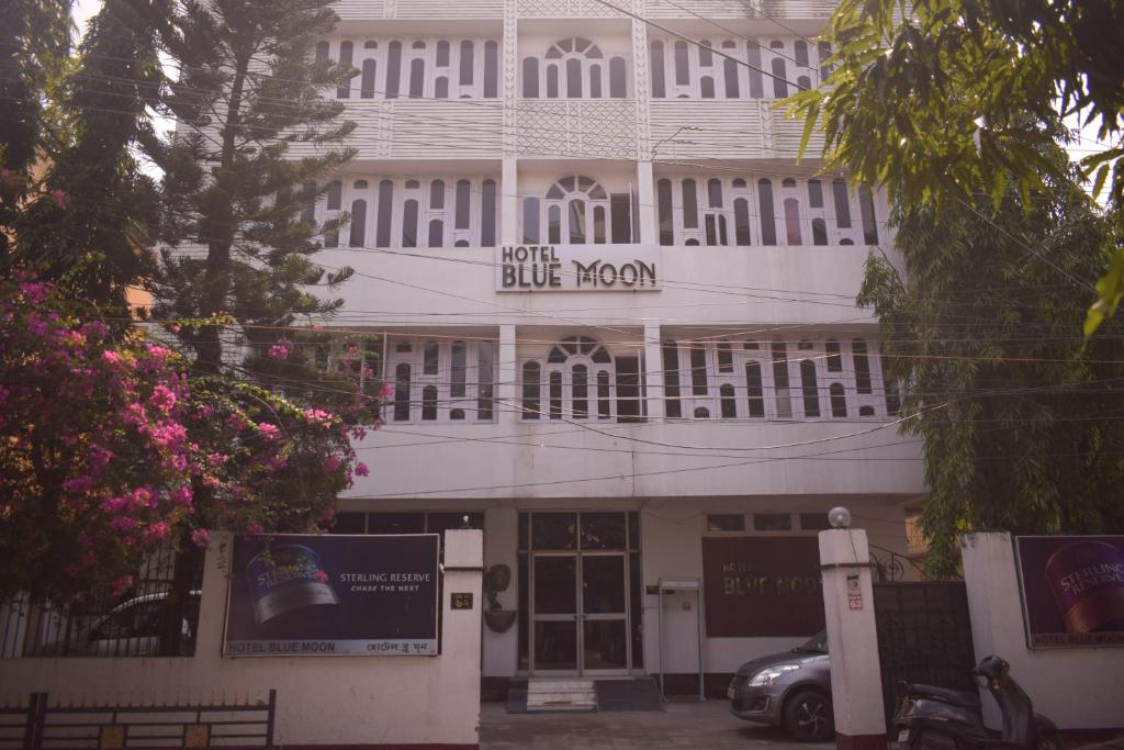 um edifício branco com uma placa de quarto azul em Hotel Bluemoon em Guwahati