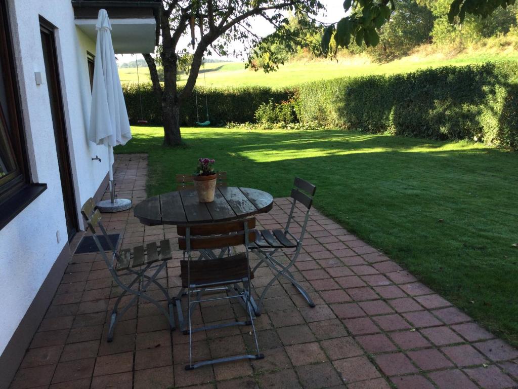 a table and chairs on a patio with a lawn at Relaxen vor den Toren Bambergs in Bischberg